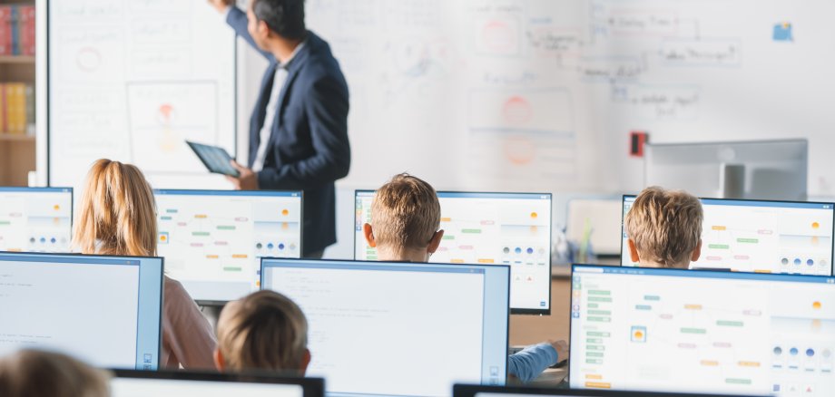 Elementary School Class: Teacher Uses Interactive Digital Whiteboard, Explains Lesson to Diverse Group of Smart Children. Kids getting Modern Education, Learn Computer Science, Software Programming